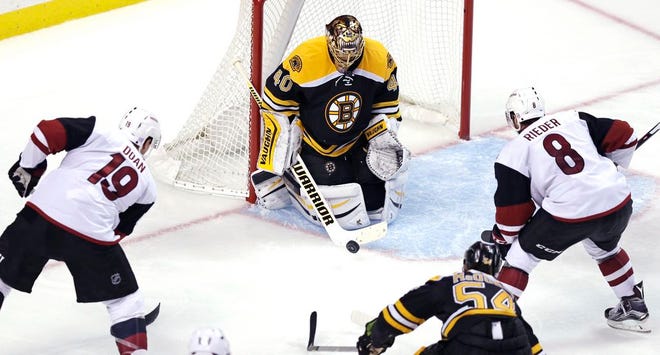 Boston Bruins goalie Tuukka Rask makes a save as Arizona Coyotes right wing Shane Doan (19) and center Tobias Rieder (8) look for the rebound during the third period in Boston, Tuesday, Oct. 27, 2015. Rask and the Bruins shut out the Coyotes, 6-0.
