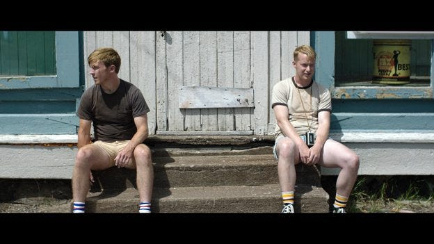 Exhausted and hungry, Charlie (Thatcher Robinson at left) and Derek (Paul Stanko) linger outside the general store in a small town. The scene was filmed in Copper City, Mich. Conributed
