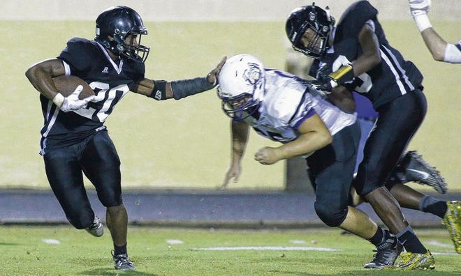 Rutherford's J.J. Willis (20) tries to stiff arm a Marianna defender during Thursday's 28-21 victory.