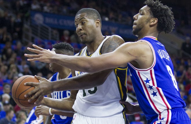 Utah Jazz forward Derrick Favors (15) keeps the ball away from Philadelphia 76ers' Jahlil Okafor (8) in the first half of an NBA basketball game, Friday, Oct. 30, 2015, in Philadelphia. (AP Photo/Laurence Kesterson)