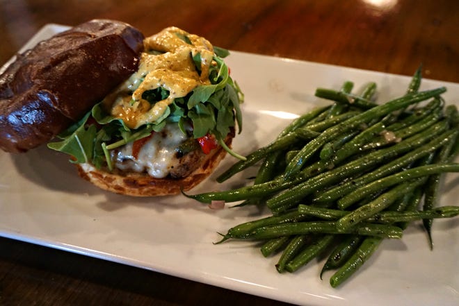 The Creole pork sausage burger, served with hericot verts, is a new menu addition that is quickly becoming a favorite.