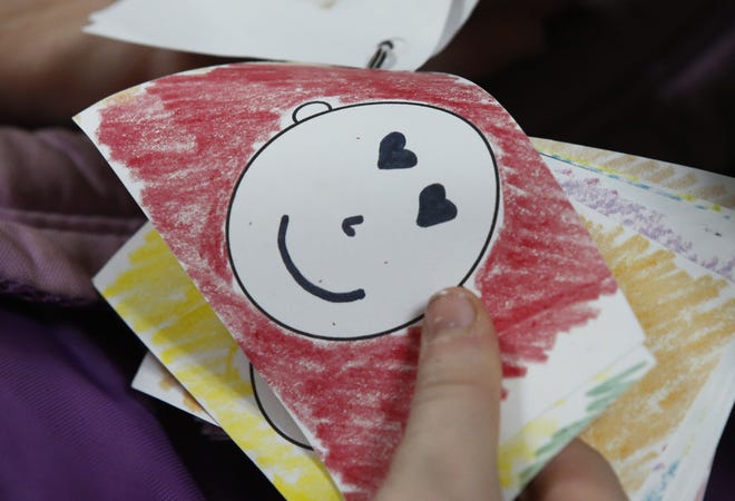 A student flips through cards which are used to express feelings during a New Hope after-school program at Mark Twain Elementary School Oct. 21 in Tulsa, Okla. The Associated Press