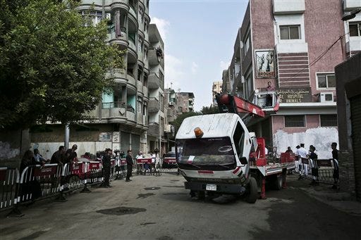 A worker on a crane descends after tying Egyptian national flags on light poles outside Zeinhom morgue, where bodies of Russian plane crash victims are kept, in Cairo, Egypt, Sunday, Nov. 1, 2015. A Russian passenger airliner crashed Saturday in a remote mountainous part of Egypt's Sinai Peninsula 23 minutes after taking off from a popular Red Sea resort, killing all 224 people on board.