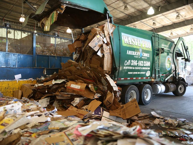 A front end loader drops part of the day's hauling of curbside recycled materials at the Leveda Brown Environmental Park on Wednesday, January 7, 2015 in Gainesville, Fla. which has recently changed control from a contracted company to Alachua County who will now process local recycled waste.