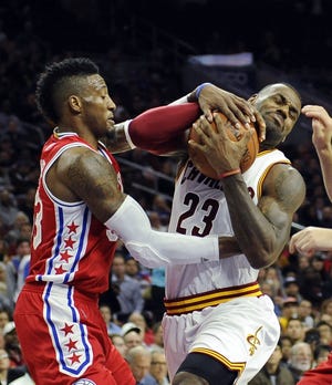 The Cavaliers' LeBron James (23) runs into the 76ers' Robert Covington and draws a foul during the first half of an NBA basketball game Monday, Nov. 2, 2015, in Philadelphia.