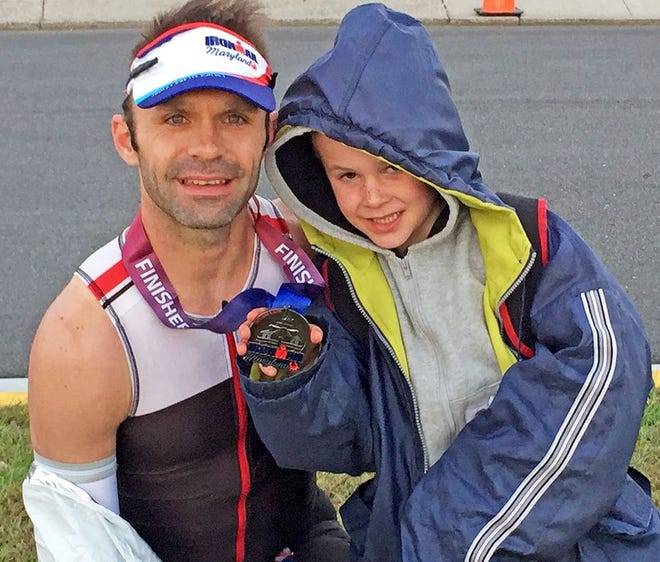 Covington Township resident Kim Hawkins recently participated in his first full Ironman event in Cambridge, MD. His son, Jackson (pictured holding his dad's Finisher Medal from the event) was on hand to greet him at the finish line.