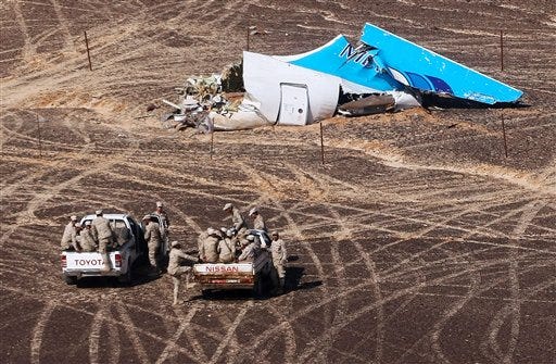 In this photo made available Monday, Nov. 2, 2015, and provided by Russian Emergency Situations Ministry, Egyptian Military on cars approach a plane's tail at the wreckage of a passenger jet bound for St. Petersburg in Russia that crashed in Hassana, Egypt, on Sunday, Nov. 1, 2015. The Russian cargo plane on Monday brought the first bodies of Russian victims killed in a plane crash in Egypt home to St. Petersburg, a city awash in grief for its missing residents.