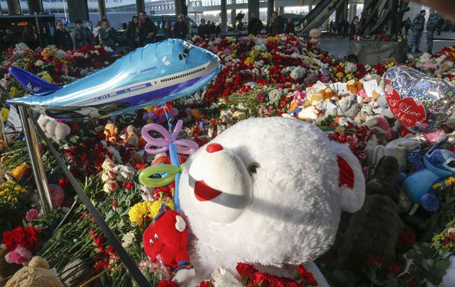 Floral tributes, toys and candles are photographed at an entrance of Pulkovo airport during a day of national mourning for the victims of the plane crash, outside St. Petersburg, Russia.