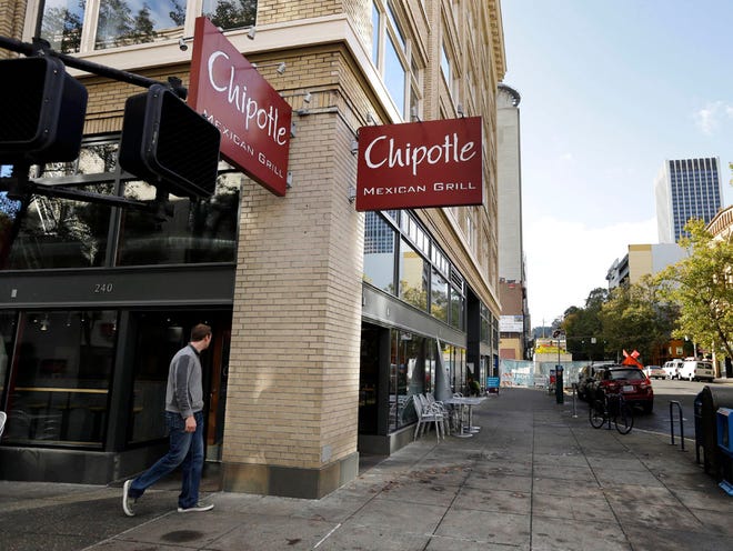 A pedestrian walks past a closed Chipotle restaurant in Portland, Ore., Monday, Nov. 2, 2015. Chipotle voluntarily closed down 43 of its locations in Washington and in the Portland area as a precaution after an E. coli outbreak linked to six of its restaurants in the two states has sickened nearly two dozen people.