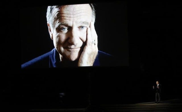 Billy Crystal takes the stage to pay tribute to the late Robin Williams, shown on a large screen, during the 66th Primetime Emmy Awards in Los Angeles on Aug. 25, 2014. (REUTERS/Mario Anzuoni)