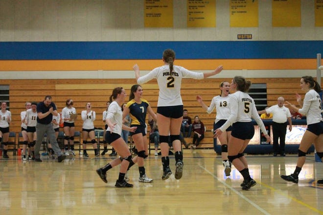 The Pirates celebrate their four-set victory over Saranac on Wednesday night.