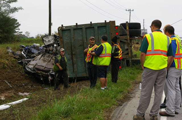 Emergency responders prepare to pull a truck carrying crushed vehicles out of a ditch along N.C. 58 North near the intersection of U.S. 13 Wednesday morning. The surplus cars were picked up in Kinston and were heading to Rocky Mount.