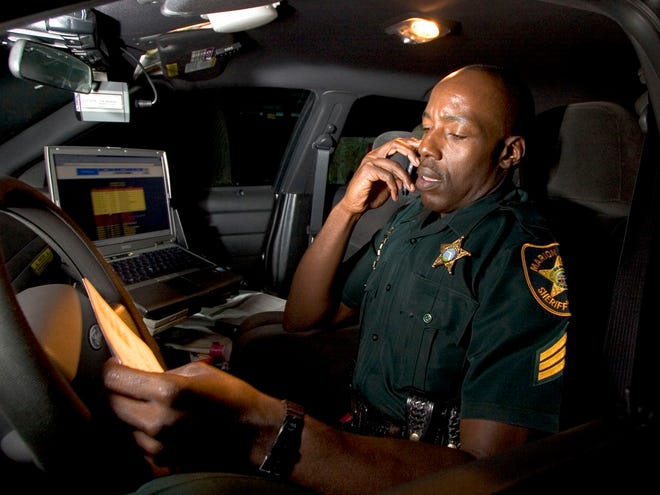 In this Feb. 21, 2006 file photo, then-Sgt. Clayton Thomas of the Marion County Sheriff's Office works in his patrol vehicle.