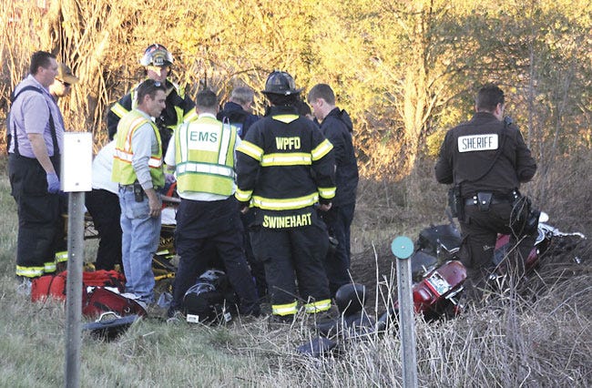Emergency personnel treat a woman who was injured in a motorcycle crash Tuesday in Mottville Township.