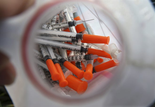 A jug of used needles to exchange for new in an industrial area of Camden, N.J. The Associated Press