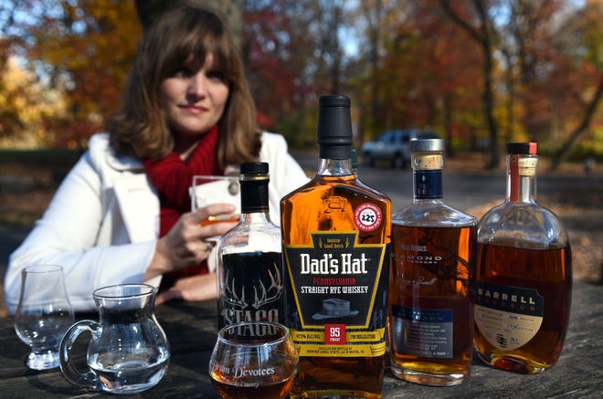 Laura Fields, founder of Dram Devotees of Bucks County, a whiskey appreciation group, shows some of the bottles they taste.