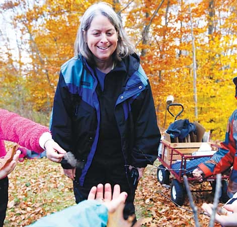 Photo by Tracy Klimek/New Jersey Herald Ridge and Valley Charter School kindergarten teacher Lisa Masi looks down at the hands of her students as they stand in their outdoor classroom in Frelinghuysen showing her things of nature they collected.