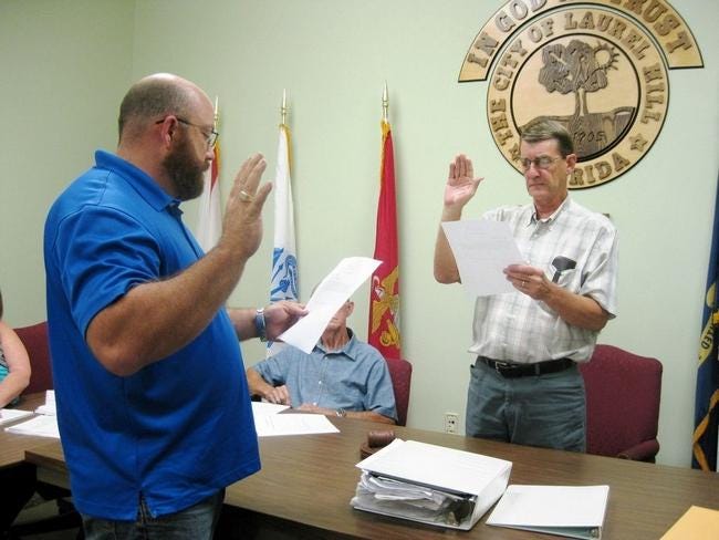 Laurel Hill City Council Chairman Larry Hendren swears new Councilman Travis Dewrell into office Nov. 5.