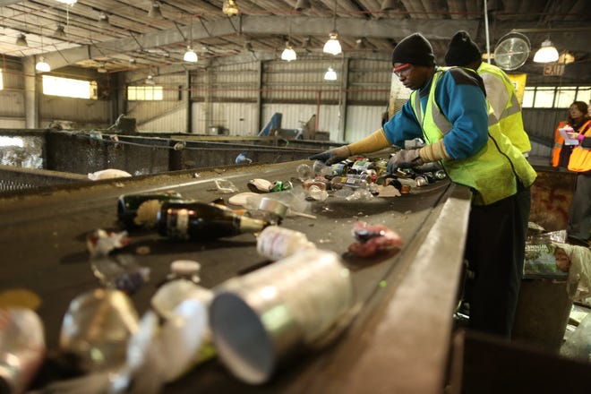 Workers separate the day's hauling of curbside recycled materials at the Leveda Brown Environmental Park in January.