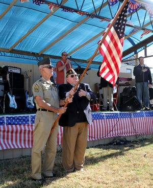 Jamie Mitchell • Times Record - SGM Adna R. Chaffee IV, left, and Sebastian County Veterans Service Officer Rick Young present the colors, Saturday, November 08, 2014, following the Veteran's Day Parade at Chaffee Crossing.