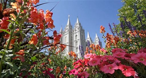 This Aug. 4, 2015,,file photo, flowers bloom in front of the Salt Lake Temple, at Temple Square, in Salt Lake City. Gay and lesbian Mormons and their supporters are reeling over a rule change by church officials that says members in same-sex marriages can be kicked out, and bars their children from being baptized unless they disavow same-sex relationships. The changes in the church handbook were sent out Thursday, Nov. 5, 2015, to local church leaders around the world. (AP Photo/Rick Bowmer, File)