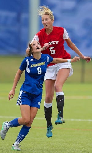 Jlilian Lang (5) of Belmont Abbey rises up for a header over Limestone's Allie Winglosky. Limestone earned a 1-0 win over the Crusaders in the conference tournament final.