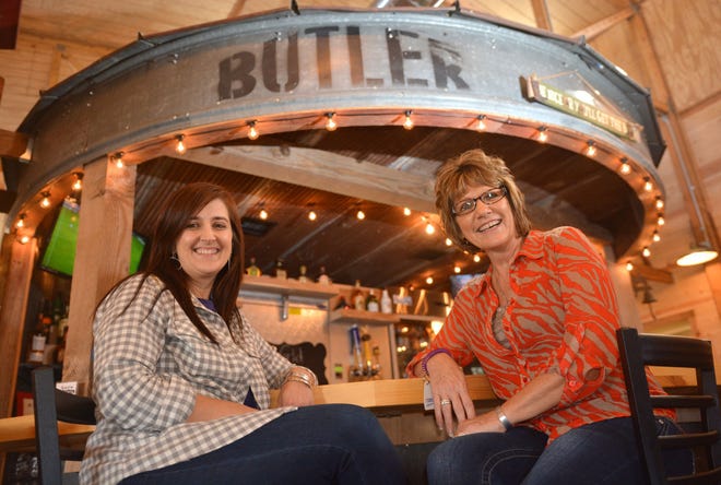 Lesley Matlack, owner, left, and Shelly Findley, manager of theBarn, pose around the grain bin-turned-bar in their restaurant on Nov. 5.