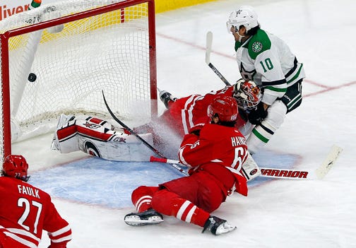 The Dallas Stars' Patrick Sharp, right, scores the go-ahead goal as Carolina goalie Eddie Luck falls after beating defenseman Ron Hainsey to the puck.