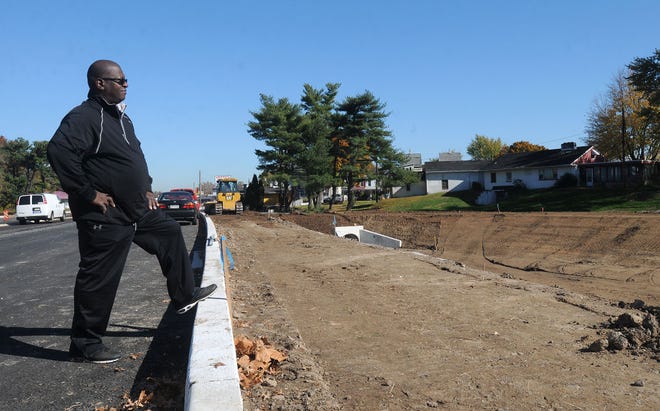 Ed Williams looks over a newly dug detention basin as part of the Route 13 revitalization project across from his Bristol home Wednesday, Nov. 4, 2015. The basin is designed to temporarily hold water and then drain into Silver Lake. Williams worries the standing water will be a haven for mosquitoes.