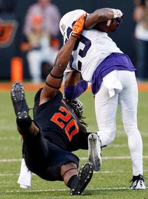 Oklahoma State's Jordan Burton (20) brings down TCU's KaVontae Turpin during a November football game between the Cowboys and Horned Frogs at Boone Pickens Stadium in Stillwater. OSU won, 49-29. Photo by Nate Billings, The Oklahoman