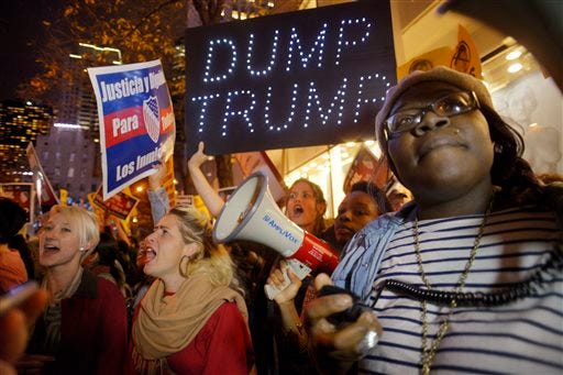 Sasha Murphy, of the ANSWER Coalition, leads demonstrators in a chant during a protest against Republican presidential candidate Donald Trump's hosting "Saturday Night Live" in New York, Saturday, Nov. 7, 2015. Despite a 40-year history of lampooning politicians while inviting some to mock themselves as on-air guests, booking a presidential candidate to host the NBC sketch-comedy show is almost unprecedented. (AP Photo/Patrick Sison)