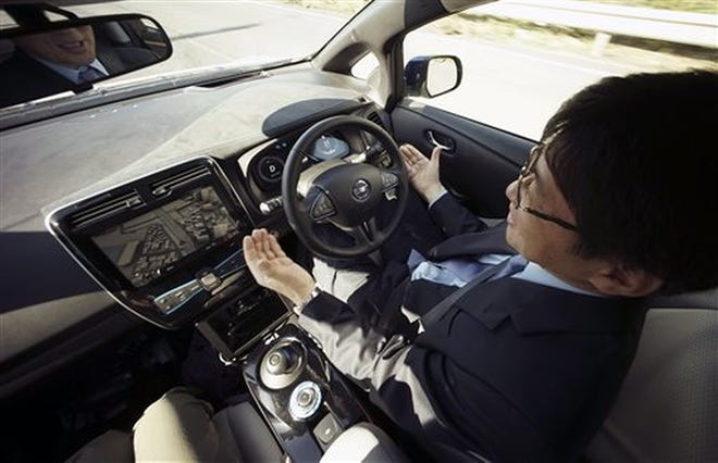 Nissan Motor Co. general manager Tetsuya Iijima lifts his hands from the steering wheel of a self-driving prototype vehicle during a recent test drive in Tokyo. 

AP/Eugene Hoshiko