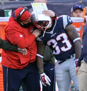 Patriots defensive coordinator Matt Patricia hugs Dion Lewis after Lewis exited the game with a knee injury in the third quarter.
