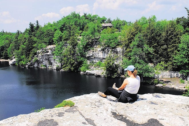 A woman sits on the cliff overlooking Lake Minnewaska in Ulster County. TIMES HERALD-RECORD FILE PHOTO