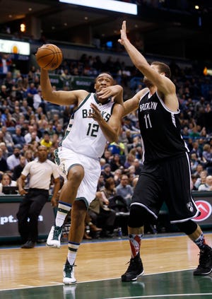 Bucks' Jabari Parker is fouled by the Nets' Brook Lopez during the second half of Saturday night's game in Milwaukee. The Associated Press