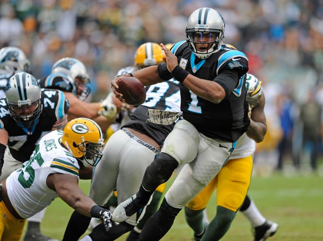 Panthers quarterback Cam Newton scrambles away from the Packers' Datone Jones (95) in the second half of Sunday's game in Charlotte, N.C. Newton threw three touchdowns and ran for another as the Panthers improved to 8-0. The Associated Press