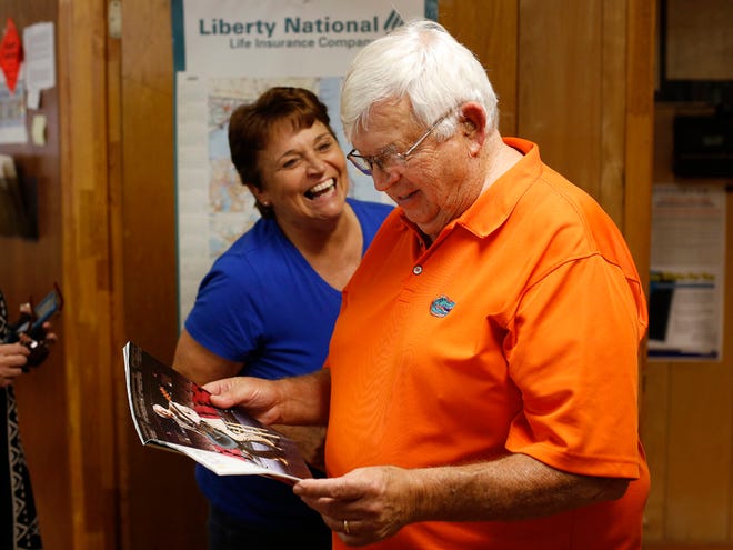 Waldo Mayor Louie Davis reads excerpts from an article in Trend Magazine about country music singer/song writer Mel Tillis while checking his mail at Waldo City Hall last Tuesday. At back is Davis' wife, Diana.