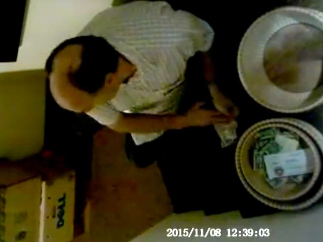 This image from video surveillance appears to show an usher at Blessed Trinity Catholic Church stuffing his pockets with money from the church's collection.