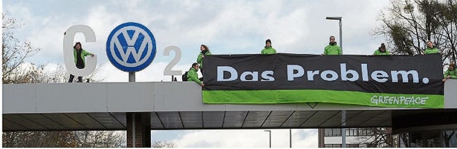 Greenpeace activists stand with letters forming "CO2" with the VW logo and a banner that reads "the problem" above the Volkswagen factory gate in Wolfsburg, Germany. The protest took place on Monday.