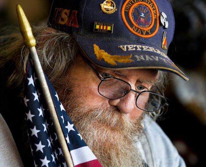 Chuck Craig of Peoria, a Navy veteran who served from '69-'71, holds a flag as he receives provisions during Goodwill's Stand Down for Homeless Veterans at Dozer Park in October.