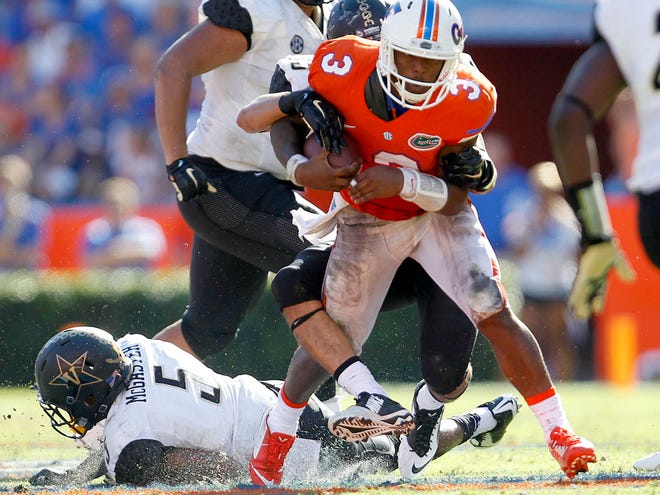 Florida quarterback Treon Harris is tackled by a Vanderbilt Commodores defender during the second half Saturday at Ben Hill Griffin Stadium. Florida defeated Vanderbilt 9-7 to clinch the SEC East.