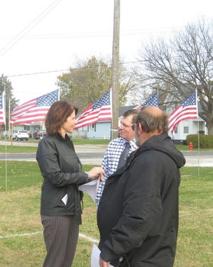 Congresswoman Cheri Bustos chats with Trent McKeown, a member of the Citizens for Veterans Memorial Committee (middle), and Alexis Mayor Dale Oberhaus before the groundbreaking ceremony for veterans memorial on Wednesday, Nov. 11.