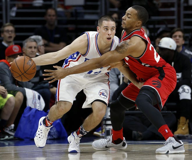 The 76ers' T.J. McConnell (left) tries to dribble past the Raptors' Norman Powell on Wednesday night, Nov. 11, 2015, at the Wells Fargo Center.