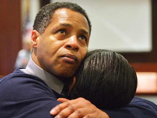 In this Dec. 5, 2013, photo, Timothy Johnson embraces a family member after he was exonerated of a 1984 killing in Houston County in Perry, Ga. Johnson said he was frightened into pleading guilty for a murder he didn't commit after police dangled him off a bridge three decades ago, brought charges against his parents and threatened him with the death penalty.