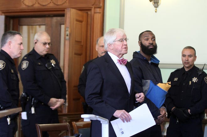 Deputy sheriffs surround Douglas Huntley, second from right, in Judge Robert Krause's Superior Court courtroom. Huntley, who was tased recently for flipping a table in Krause's courtroom after being found guilty of firearms and other charges, apologized Monday when he appeared with his lawyer, Mark Smith, for a hearing on a new trial. The Providence Journal/Mary Murphy