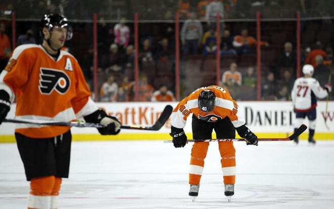 Philadelphia Flyers' Vincent Lecavalier (center) and Mark Streit skate off the ice after the Flyers lost 5-2 to the Washington Capitals on Thursday, Nov. 12, 2015.