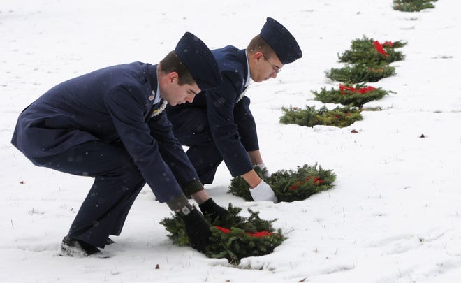 Civil Air Patrol cadets decorate graves at Massachusetts National Cemetery on a snowy afternoon in 2013. Although donations to the Wreaths Across America program have grown each year, they still fall far short of allowing all 64,000 grave markers at the Bourne veterans cemetery to be decorated. Steve Heaslip/Cape Cod Times File