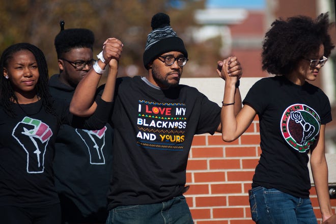 University of Missouri graduate student Jonathan Butler, center, walks Monday at Traditions Plaza on the MU campus with other members of Concerned Student 1950 after UM System President Tim Wolfe said he was resigning. Butler, who went on a hunger strike demanding new leadership, is from Omaha, Neb.