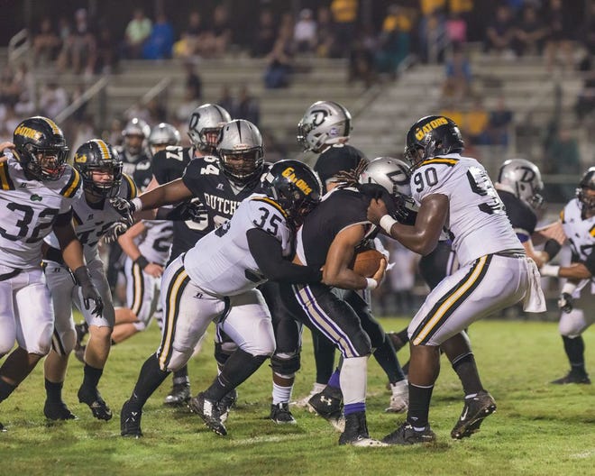 Dutchtown's Fitell Bolding is swarmed by Elliot Turner (No. 90), Anthony Wilson (No. 35) and other Gator defenders. Photo by DKMoon Photography.
