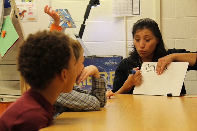 A classroom aide in Holland West K-7 kindergarten teacher Cynthia Marroquin's room leads a group of students in an activity Monday, Oct. 26, in Spanish. Marroquin's classroom is a two-way bilingual immersion program, in which 90 percent of class time is in Spanish and 10 percent is in English. Sentinel File